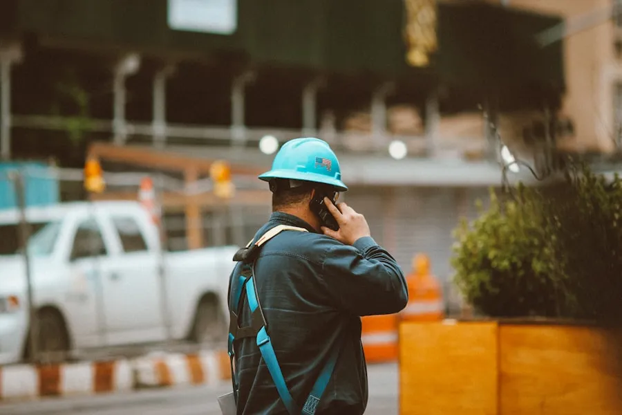 Contractor in a hard hat taking a phone call at a jobsite